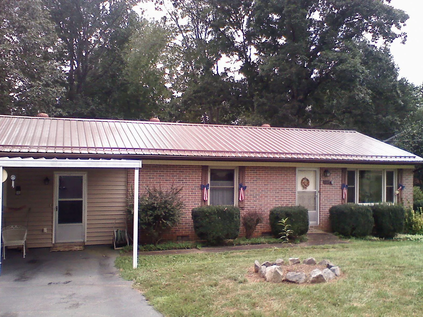 Bronze metal roof and carport on a brick ranch home — Roof Repair work by our crew in Linwood